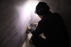 タイル壁にコンセントの取付枠を固定する作業